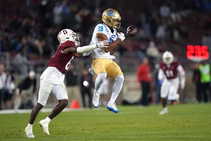 Oct 21, 2023; Stanford, California, USA; UCLA Bruins wide receiver Kyle Ford (19) bobbles a pass berfore completing the catch against Stanford Cardinal cornerback Collin Wright (6) during the fourth quarter at Stanford Stadium. Mandatory Credit: Darren Yamashita-USA TODAY Sports